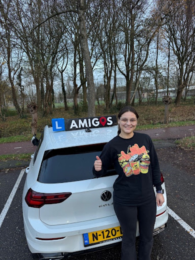 Leerling van Rijschool Amigos naast de lesauto